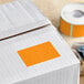 A white box with a roll of Lavex fluorescent orange rectangular inventory labels.