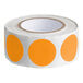 A roll of orange circle stickers with white backing.