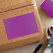 A cardboard box with a purple Lavex rectangular label on it.