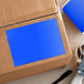 A close-up of a blue Lavex rectangular inventory label on a cardboard box.