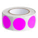 A roll of pink round inventory labels with a white background.