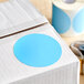 A roll of Lavex sky blue round paper labels with a blue circle on the box.