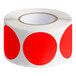 A roll of Lavex fluorescent red round inventory labels with a white background.