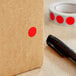 A brown box with a red circle label next to a black marker.
