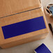 A cardboard box with a dark blue rectangular label on it.