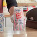 A person holding a Bagcraft clown popcorn bag full of popcorn.