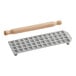 A grey rectangular Imperia ravioli mold with square holes and a rolling pin.