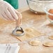 A person using an Imperia Tagliaravioli circle cutter to make ravioli.