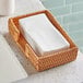 A wicker basket on a bakery counter with a stack of white Morcon Valay guest towels.