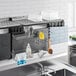 A black Cambro Camshelving sink station above a kitchen sink.
