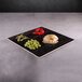 An Elite Global Solutions square faux zebra wood melamine serving board with food on it on a table.