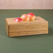 A rectangular faux bamboo modular riser with apples on top of it.