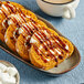 A plate of cinnamon rolls with Lyons Cinnamon Flavoring Sauce drizzled on top.