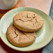 A plate of individually wrapped Red Plate Foods vegan ginger cookies on a table.