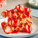 A plate of waffles with Lyons strawberry flavoring sauce and strawberries.