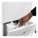 A hand opening a white machine with grey accents.