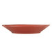 A Libbey round barn red porcelain soup and salad bowl with a small handle.