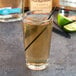 A Libbey highball glass filled with a drink and a straw.