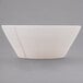 A white Libbey serving bowl with a curved edge on a gray surface.