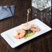 A Libbey rectangular white porcelain plate with shrimp and vegetables.