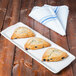 A Libbey rectangular porcelain tray with three scones on it.