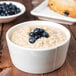 A Libbey round cream porcelain oatmeal bowl filled with oatmeal and blueberries.