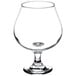 A Libbey Embassy brandy glass with a small amount of liquid in it.