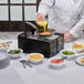 A Chef Master black cold rolled steel collapsible butane stove cover on a table in a hotel buffet.