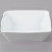 A white square bowl on a gray surface.