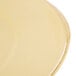 A close-up of a Libbey Farmhouse butter yellow porcelain plate with a wide rim.