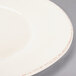 A close up of a Libbey round cream porcelain plate with a wide rim.