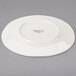 A Libbey round cream porcelain plate with a wide rim on a white background.