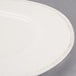 A close up of a Libbey Farmhouse round cream porcelain plate with a wide white rim.