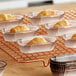 A tray of Novacart brown oval baking cups filled with pastries on a cooling rack.