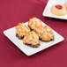 A Libbey Ultra Bright White Coupe Square porcelain plate with coconut cookies on it.