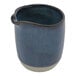 An indigo blue ceramic pitcher with a white rim and handle.