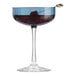 A Libbey blue coupe glass with a cherry in it.