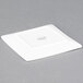 A Libbey white square porcelain plate on a gray surface.