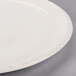 A white Libbey round porcelain platter with a rim.