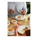 A man eating food on a Libbey white porcelain plate.