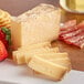 A plate with cheese slices, strawberries, and crackers.