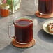 A glass mug of Maxwell House Original Roast coffee on a table.