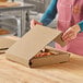 A woman opening a Choice Kraft corrugated pizza box.