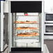 A Hatco Flav-R-Fresh pizza display cabinet with a circle rack of pizzas inside.