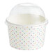 A white paper frozen yogurt cup with a dome lid and colorful polka dots.