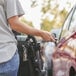 A woman uses a KEY-BAK Snapback keychain to unlock a stroller.