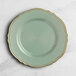 A Visions eucalyptus round plastic plate with a gold vintage rim.