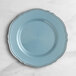 A Visions steel blue plastic plate with silver vintage trim on a marble surface.