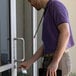 A man using a KEY-BAK Sidekick clear plastic badge holder with an orange lanyard.
