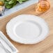 A Visions white plastic plate with a silver vintage rim on a table.